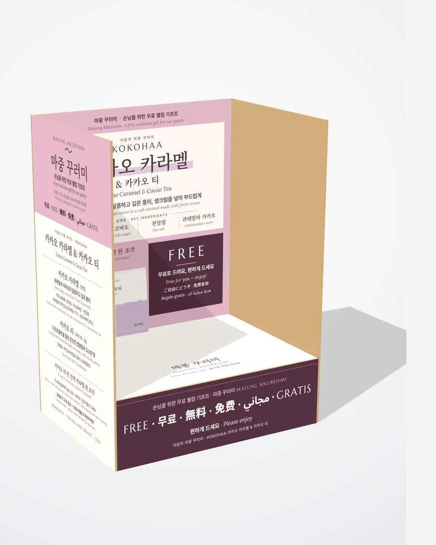 코코하 카카오 카라멜 마중 꾸러미 매대 3D 시안. 분홍과 자두색 매대에 카카오 카라멜 & 카카오 티 안내와 FREE 칸이 있다.